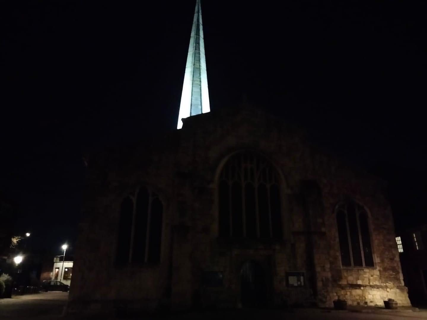 A church with a steeple lit up at night