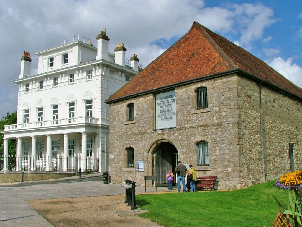 A large stone building with a green portable toilet in front of it