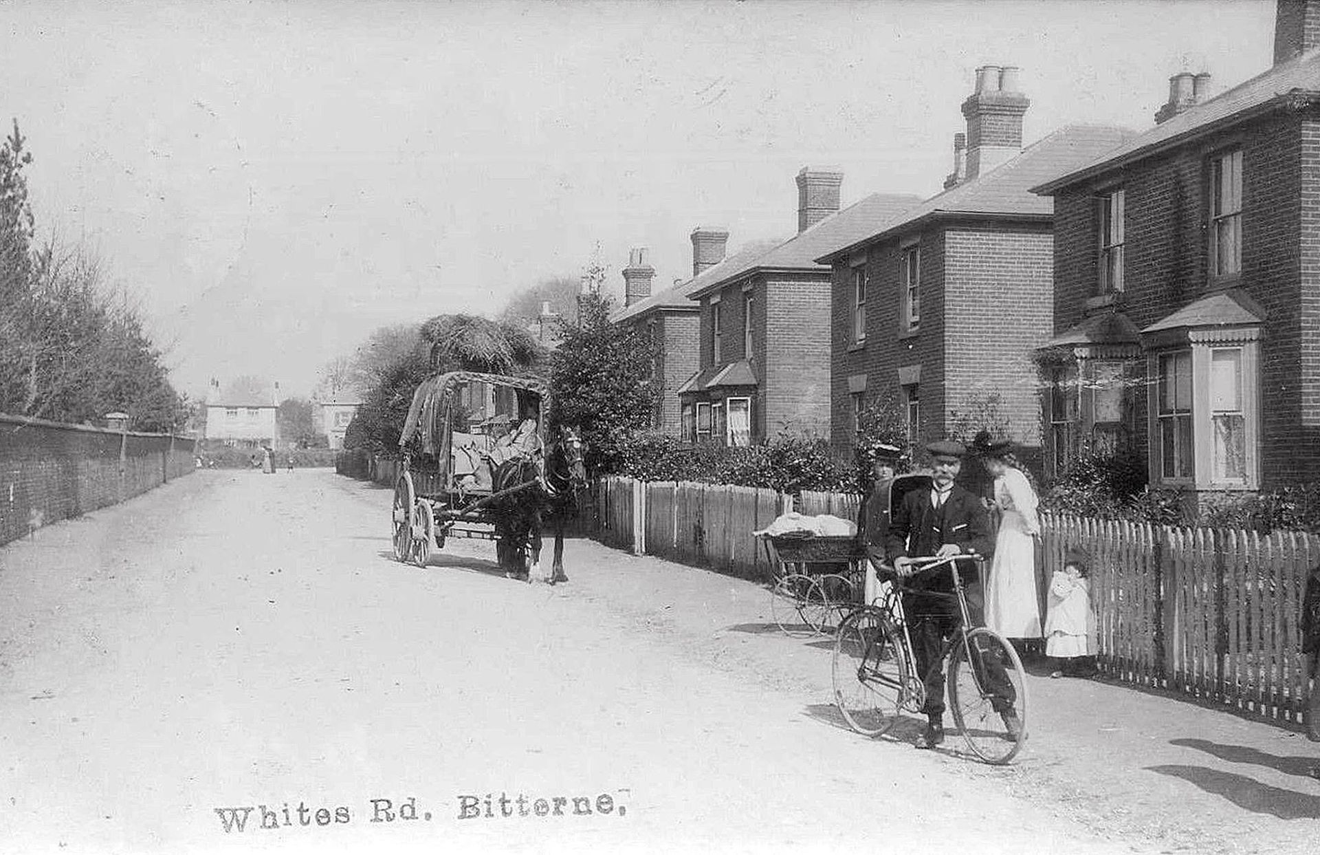 A black and white photo of a horse drawn carriage on a street.