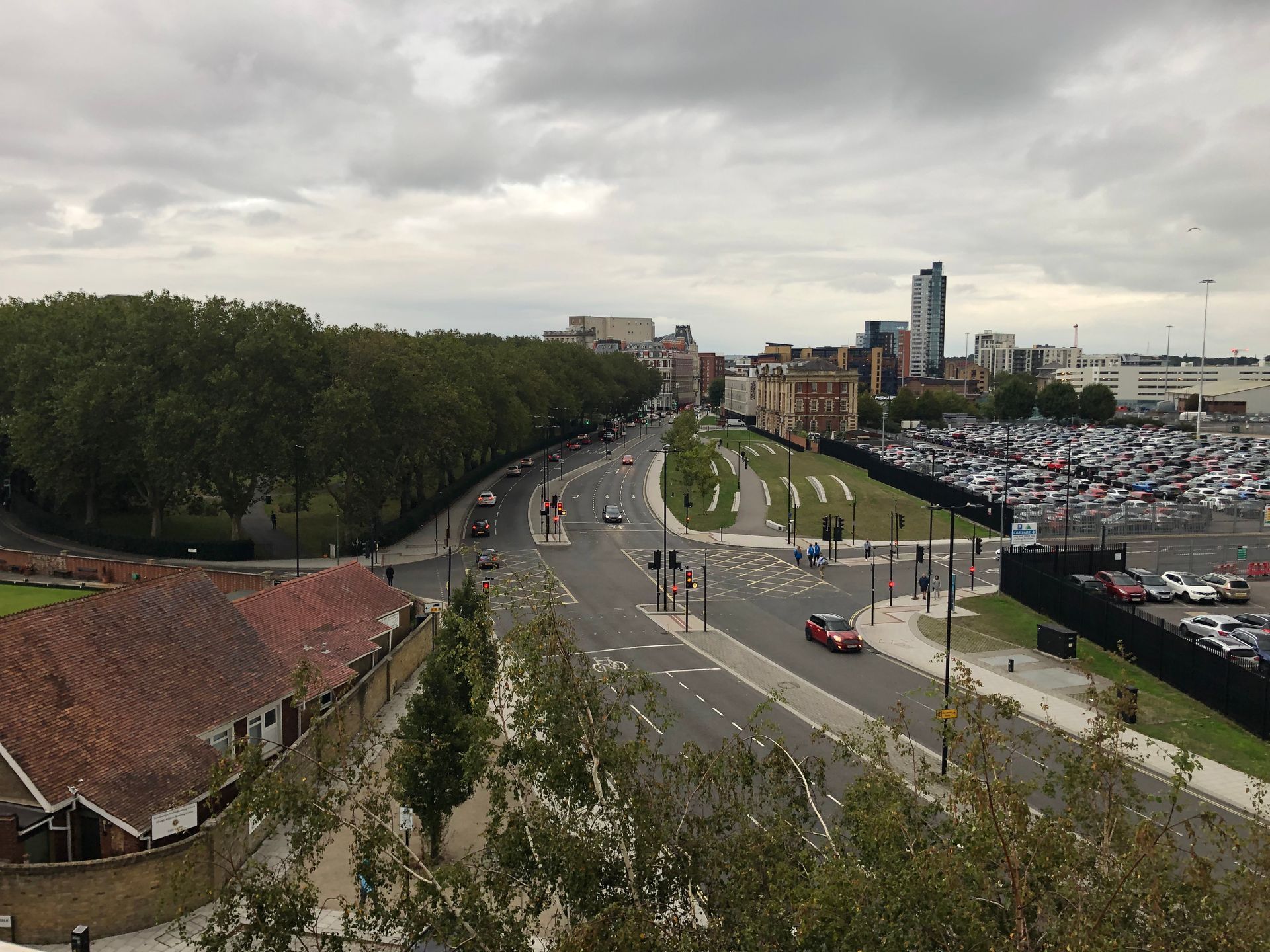 An aerial view of a city street with cars driving down it