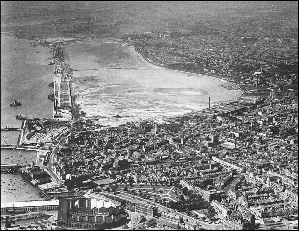 An aerial view of a city with a large body of water in the background