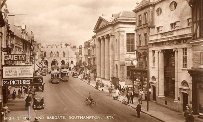 A black and white photo of a city street with a sign that says safety