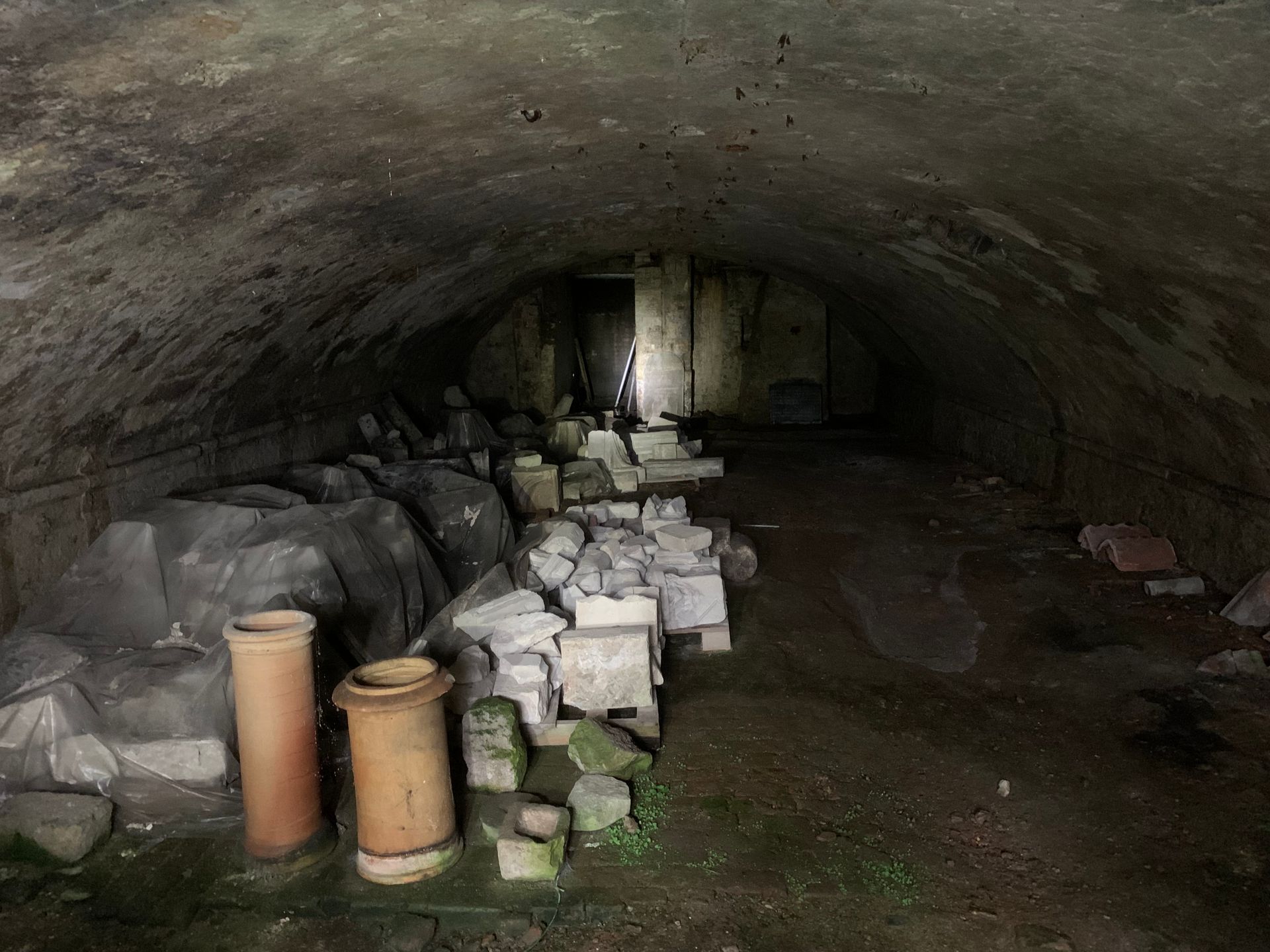 A dark cave filled with rocks and pipes.