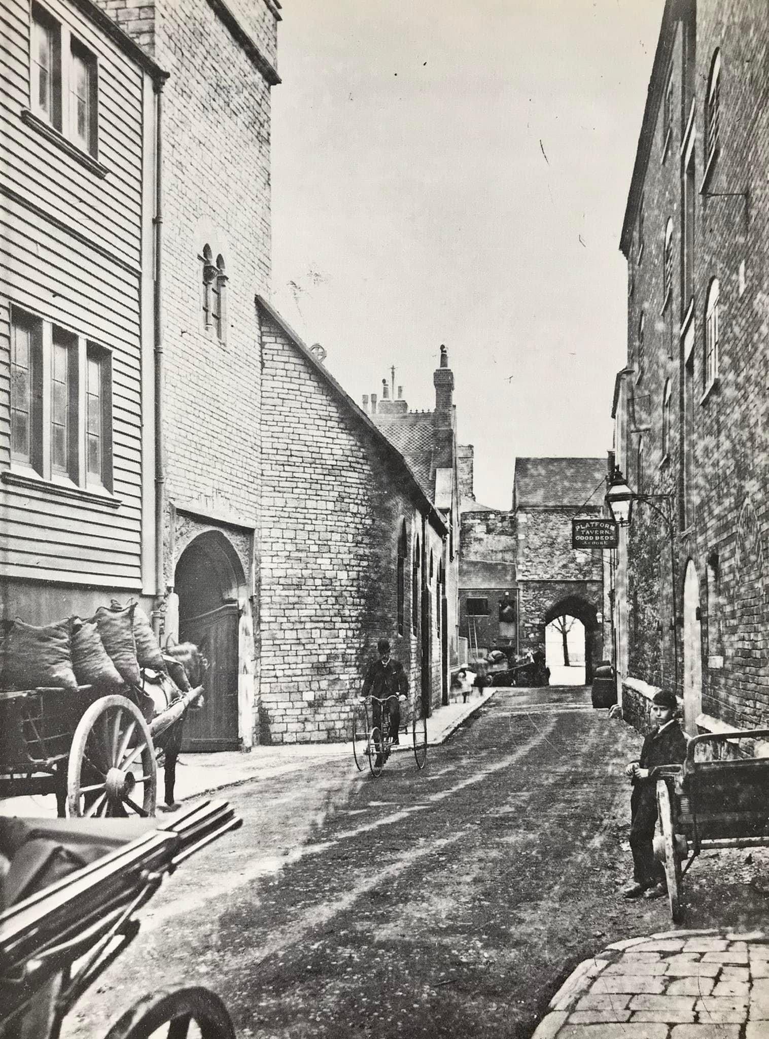 A black and white photo of a narrow street