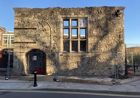 A stone building with a fence around it and a window.