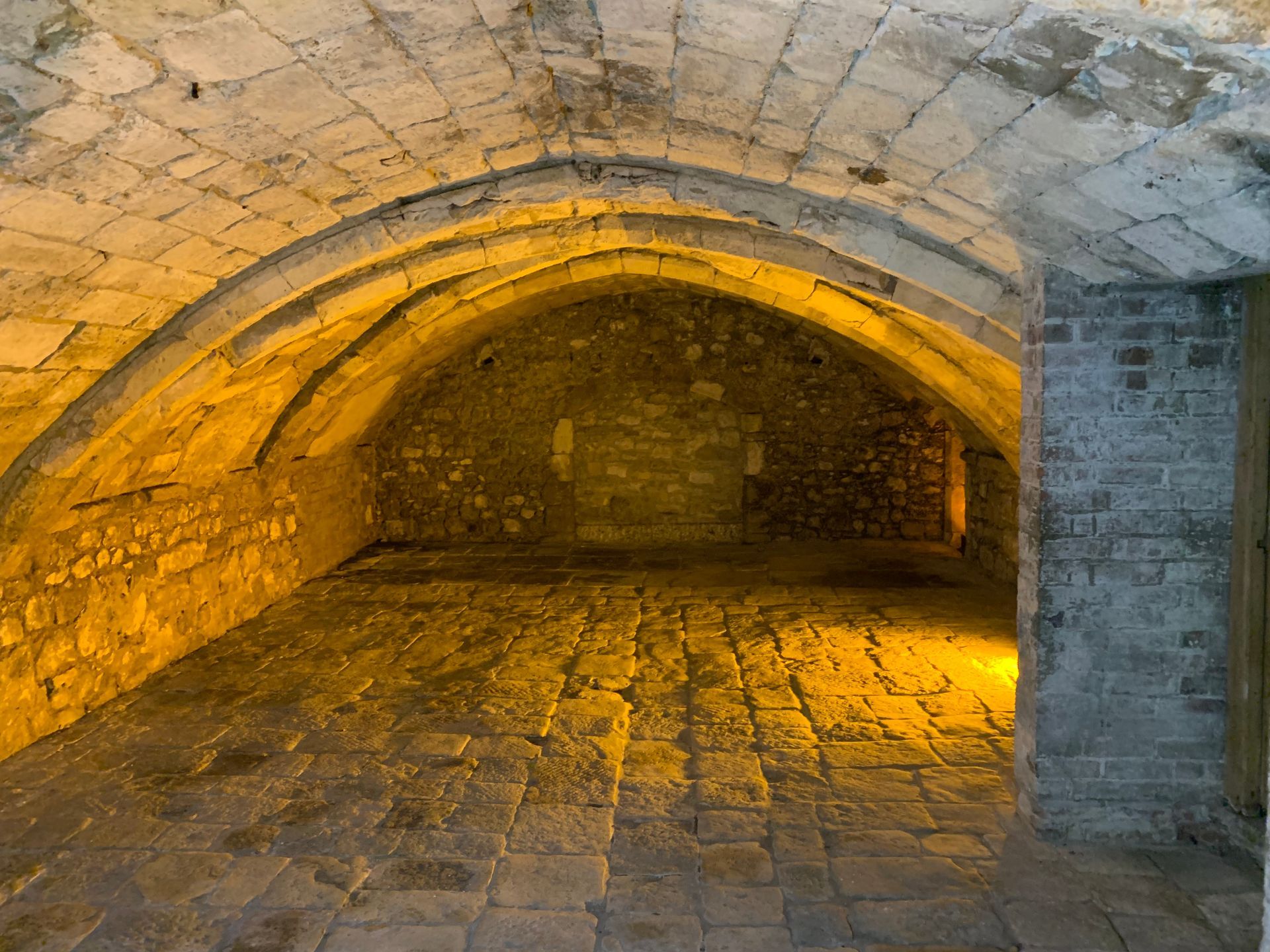 A brick tunnel with a yellow light shining through it