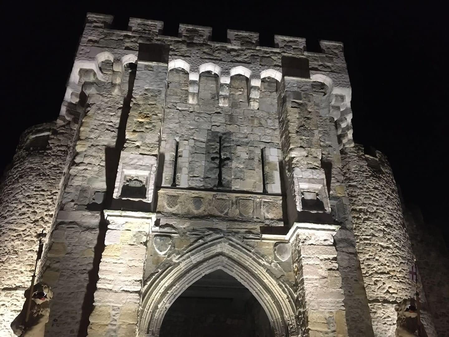 A large stone building is lit up at night.