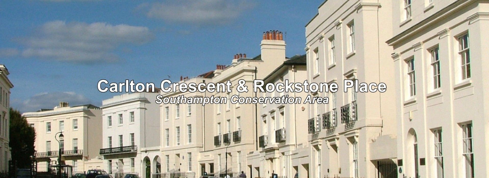 A row of white buildings with a blue sky in the background