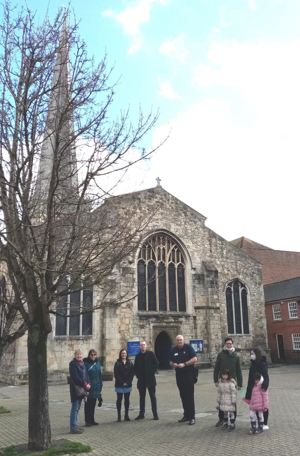 A group of people are standing in front of a church.
