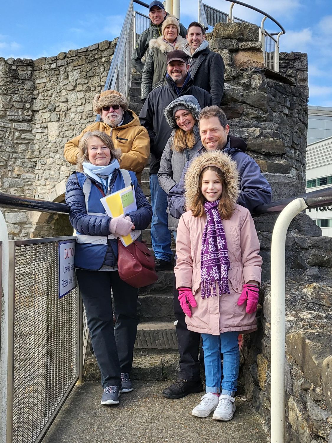 A group of people are standing on top of a stone staircase.