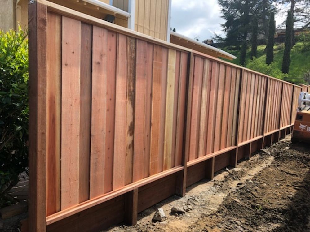 A wooden fence is being built in front of a house.