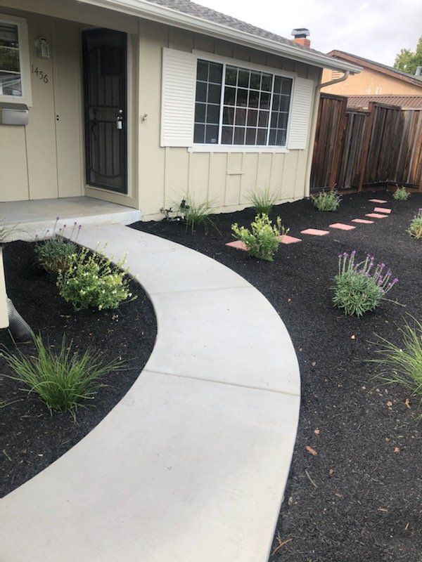 A house with a concrete walkway leading to the front door