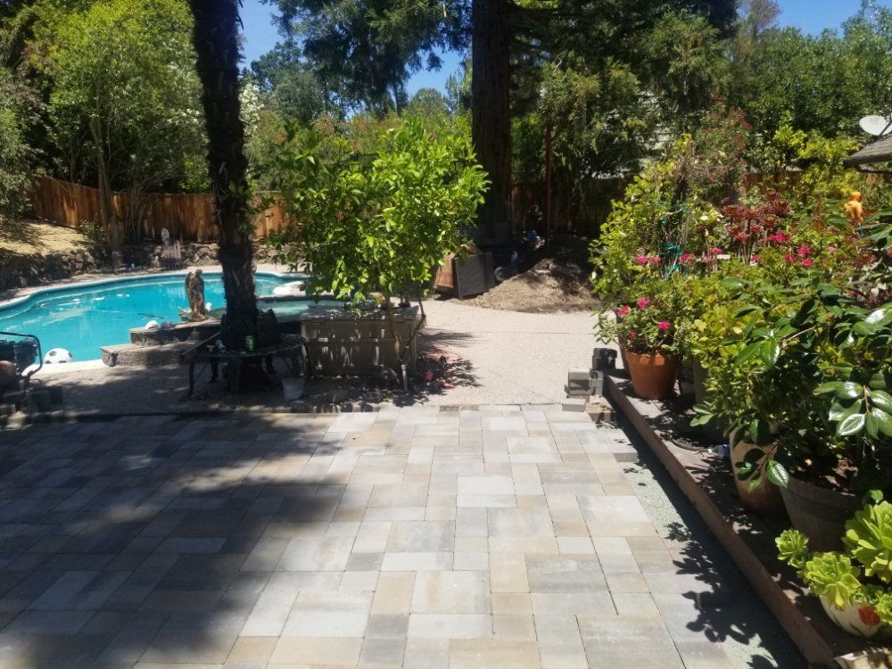 A patio with a swimming pool in the background