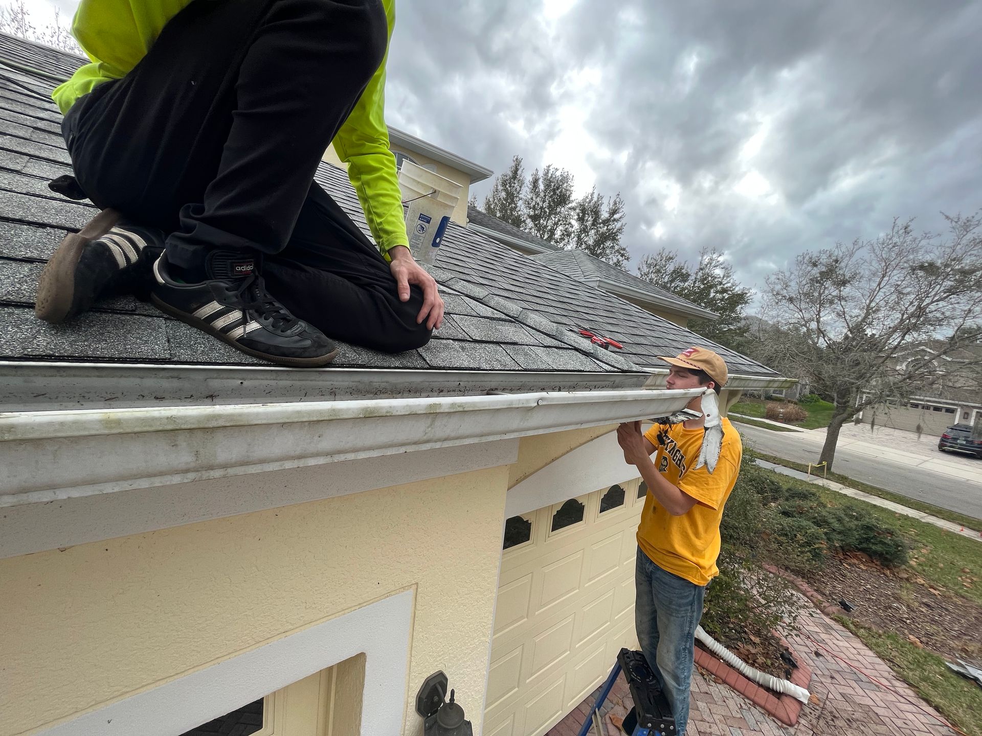Two men are working on the roof of a house.