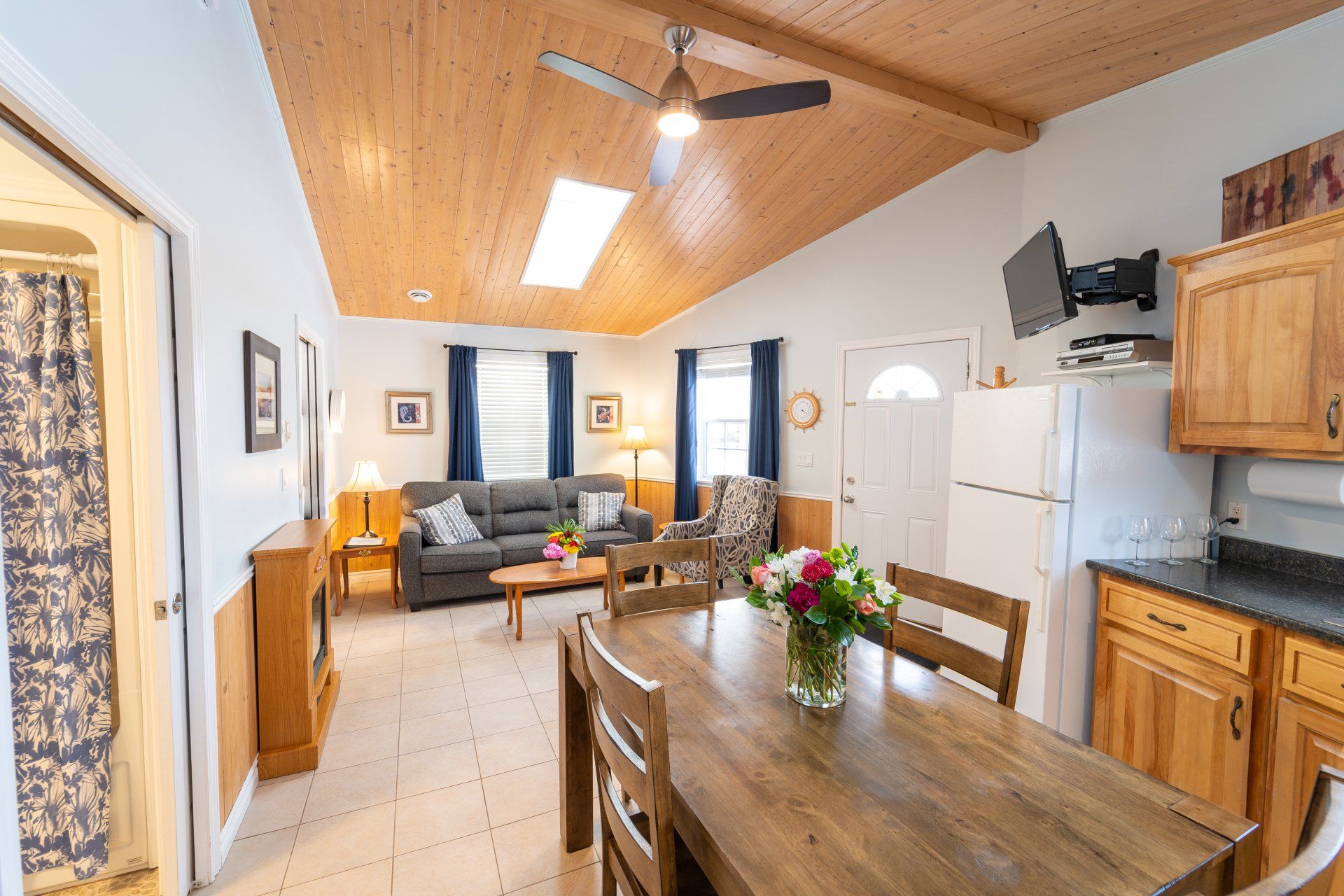 open concept dining and living room with vaulted ceilings and sky lights, the cottages name is Low Tide