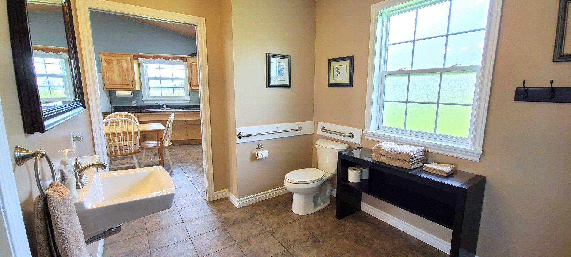barrier free bathroom with toilet that has grab bars beside and behind it