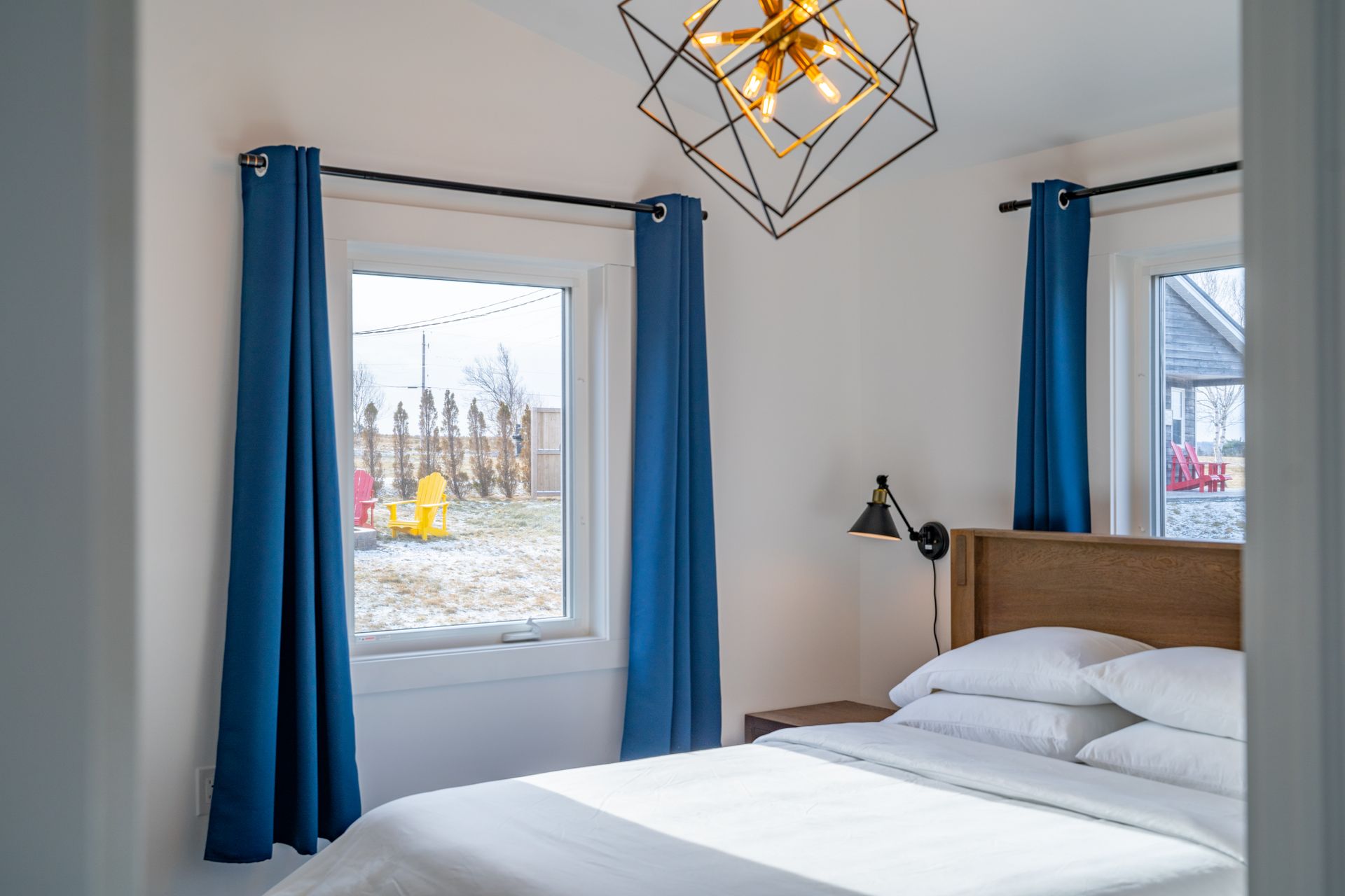 Bright bedroom, with white queen bed and nightstands.