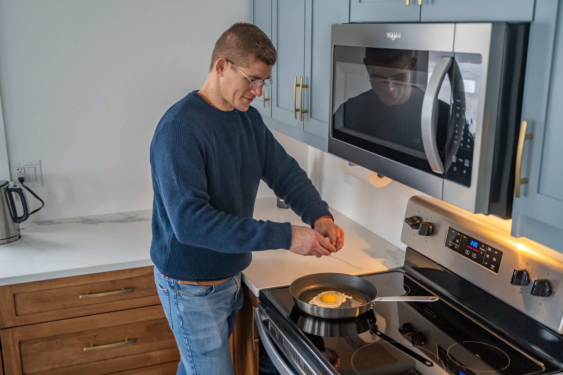 man cooking breakfast in the cottage kitchen