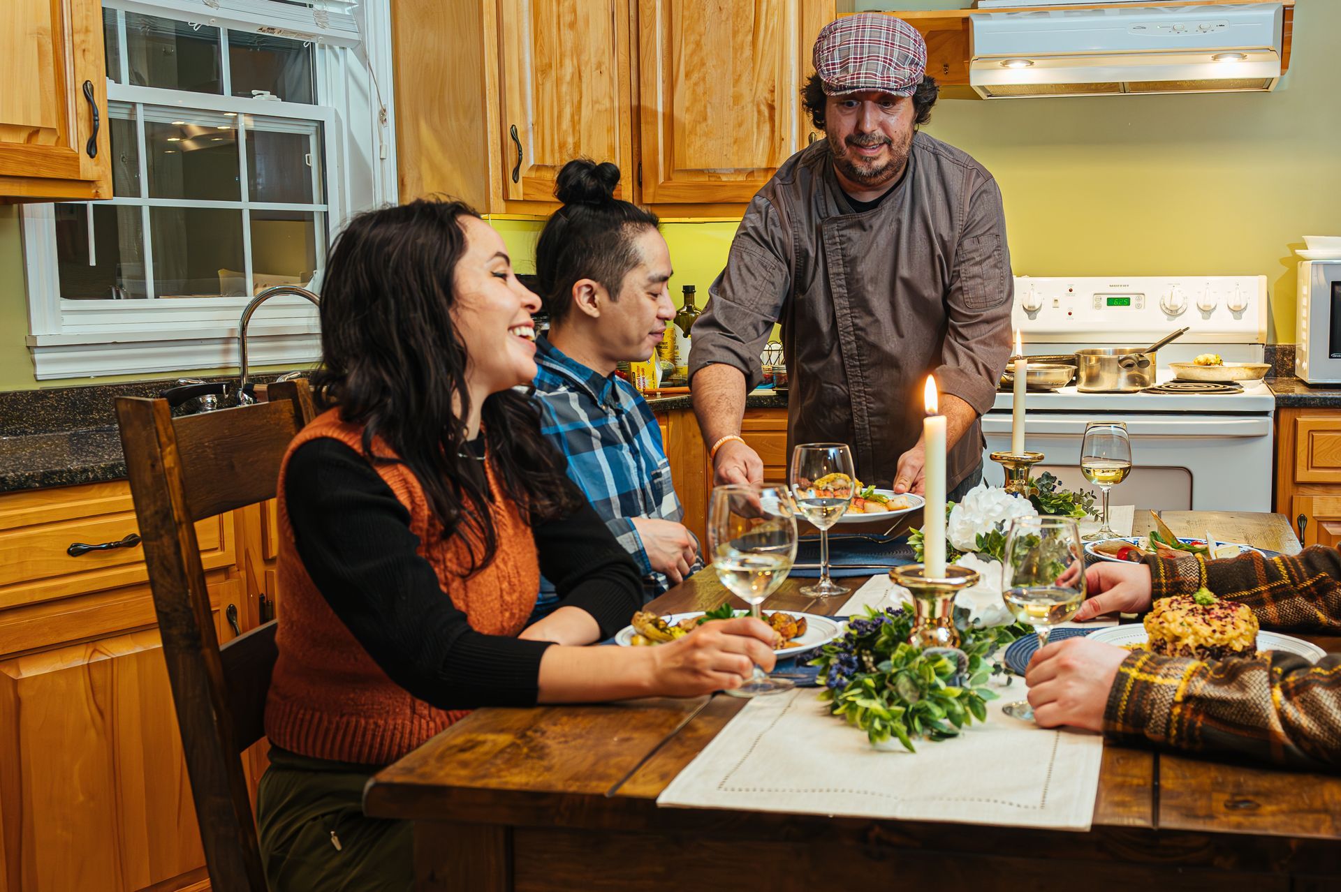 Happy couple enjoying a cozy moment in a cottage, raising a toast with a glass of wine and beer.