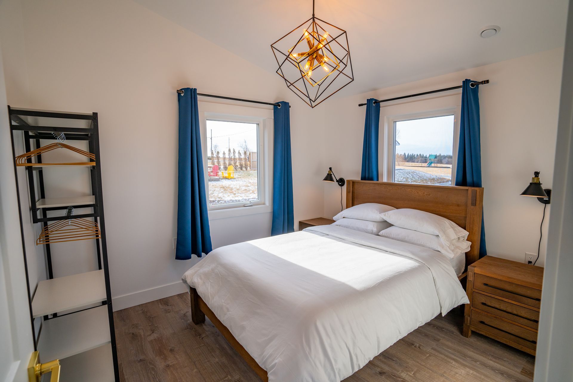 Bright bedroom, with white queen bed and nightstands.