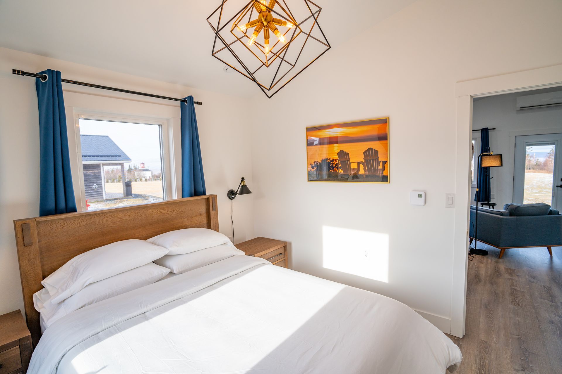 Bright bedroom, with white queen bed and nightstands.