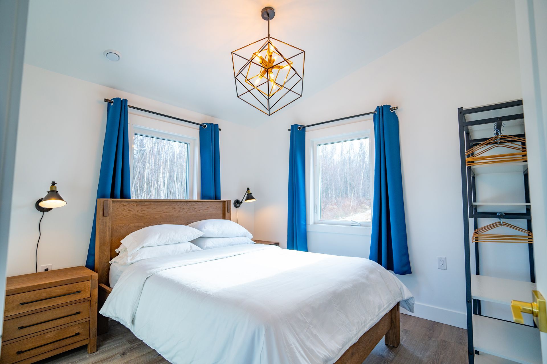 Bright bedroom, with white queen bed and nightstands.