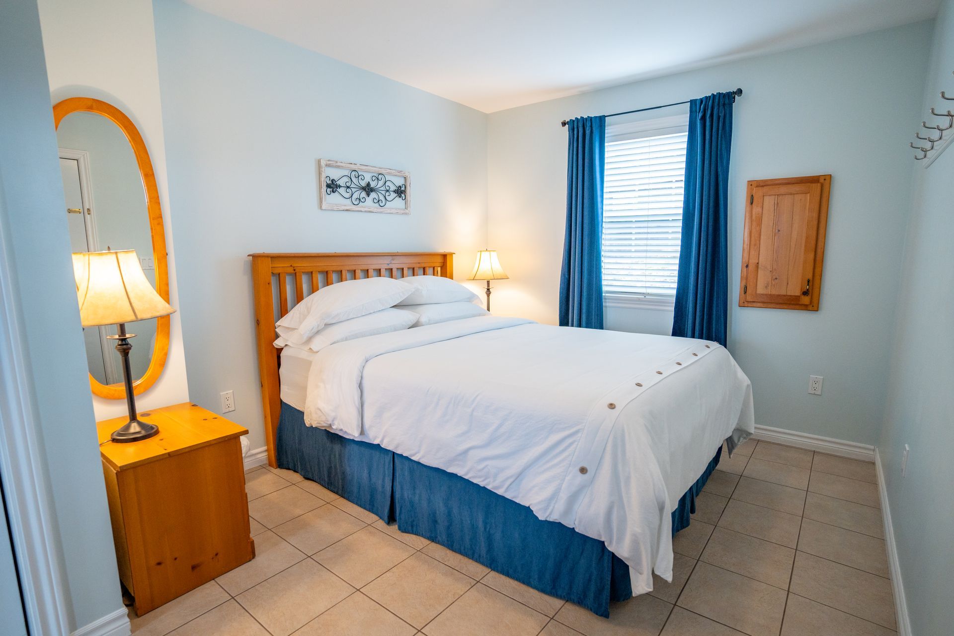 Bright bedroom, with white queen bed and nightstands.