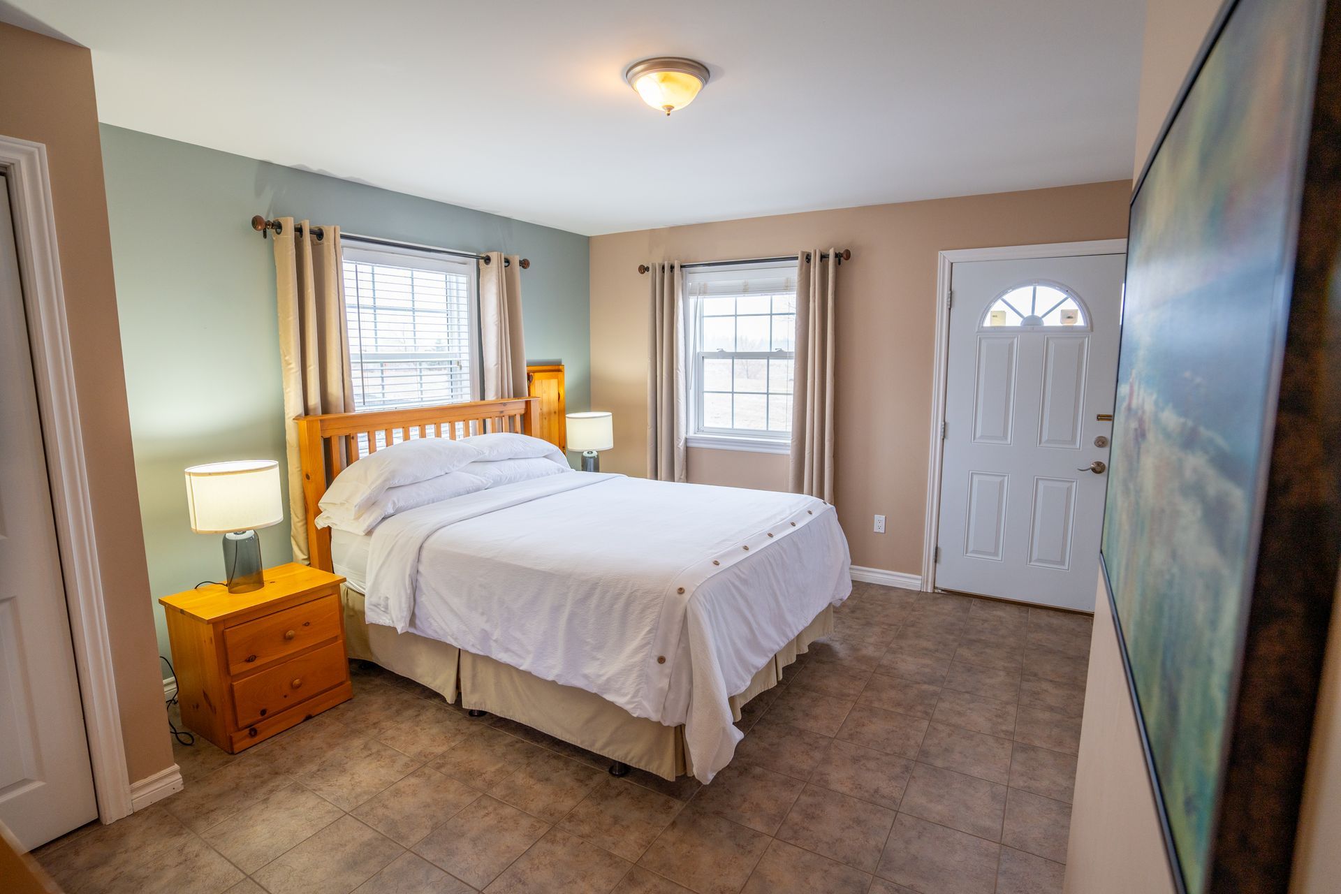 Accessible cottage, bed room with queen bed, nightstands, a dresser.