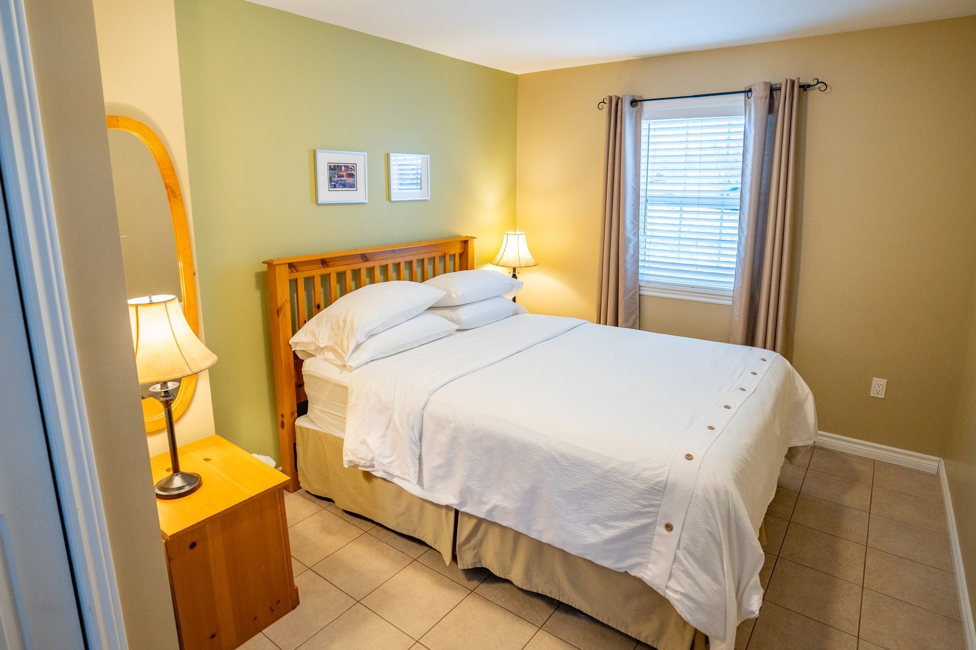 Bright bedroom, with white queen bed and nightstands.