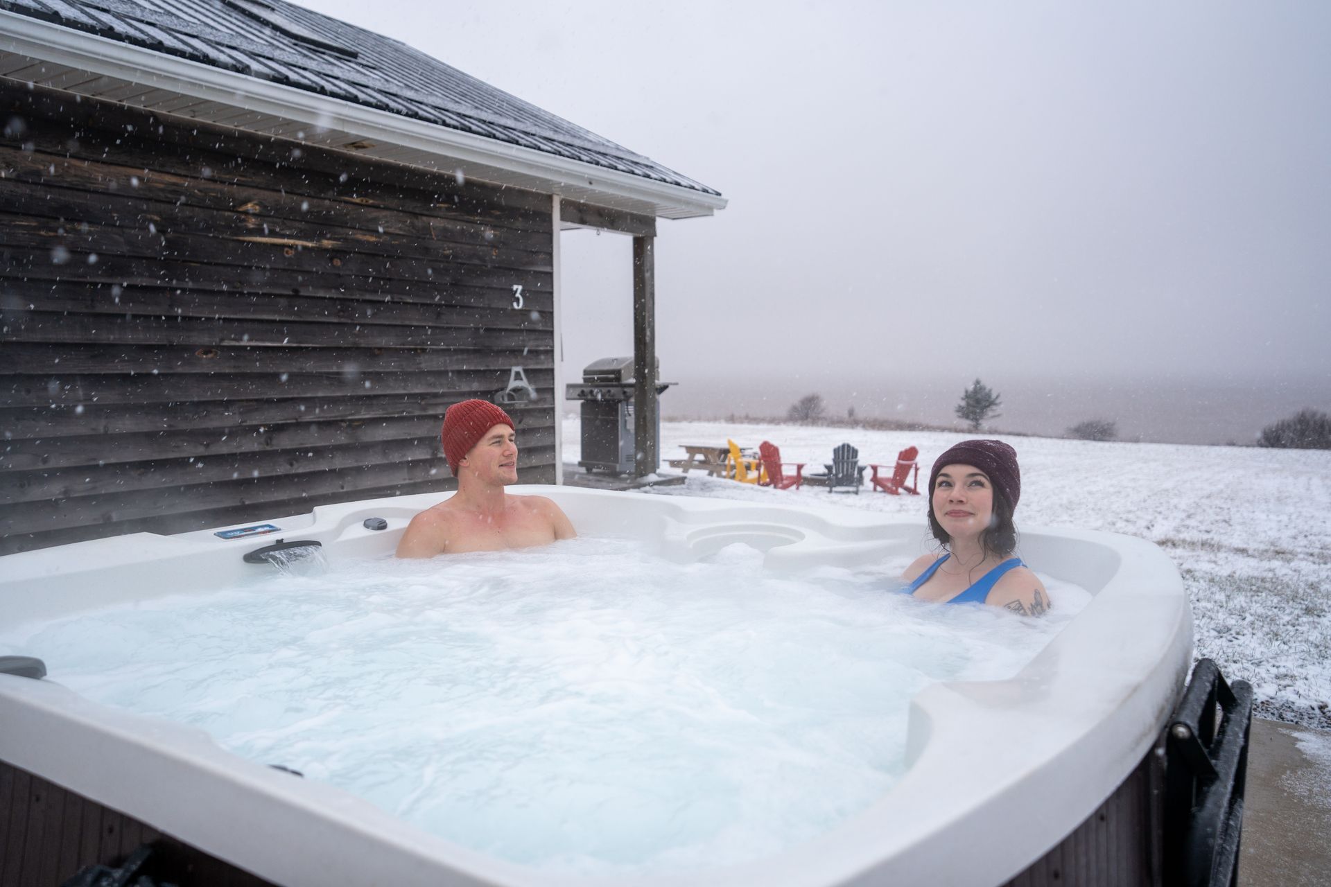 person in a hot tub with the bay of fundy in the background