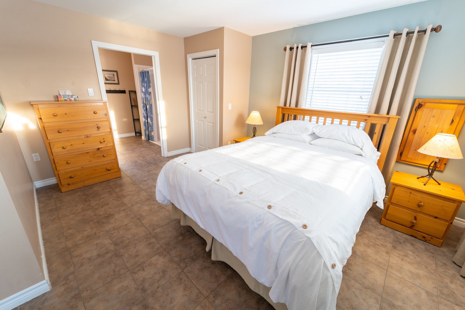 Queen bed with white linens, the cottages name is High Tide and it is a one bedroom cottage