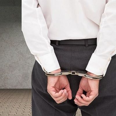 Young businessman wearing handcuffs - criminal defense lawyer, criminal defense attorney in Ocala, FL