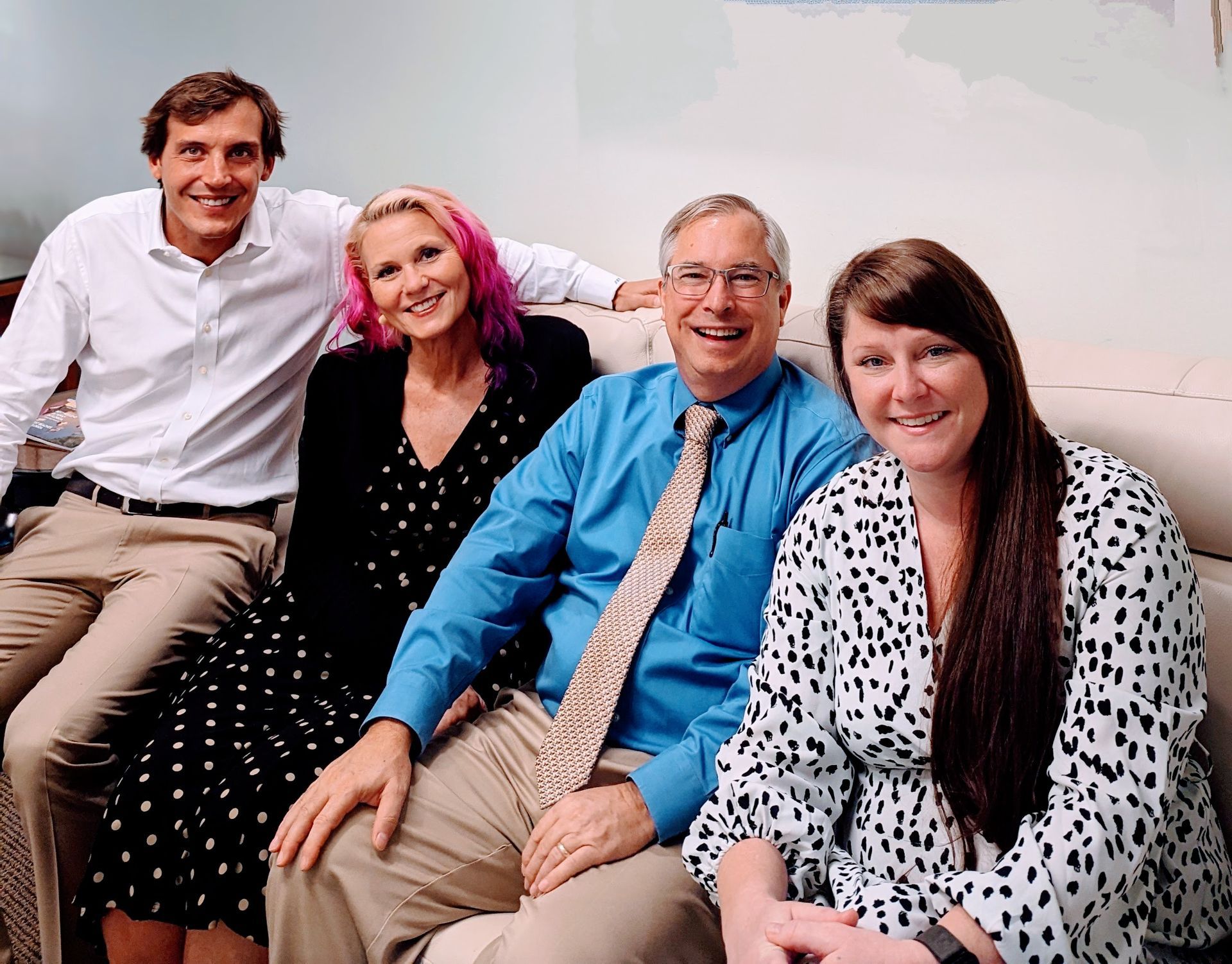 Couple embraces at a table, meeting with a financial advisor in an office setting.