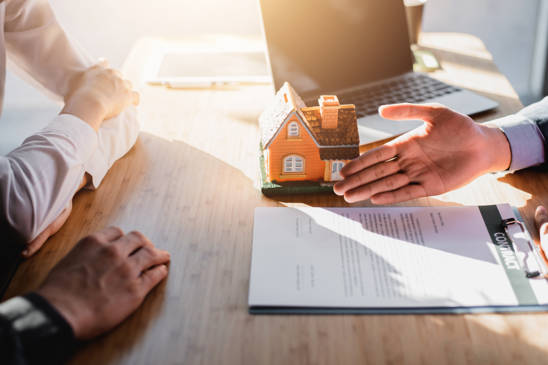 A man is smiling while sitting in front of a laptop computer.