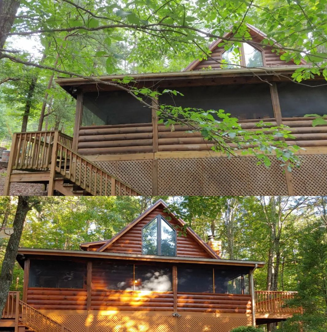 Cabin with wooden exterior, screened porch, and triangle-shaped roof set in a wooded area.