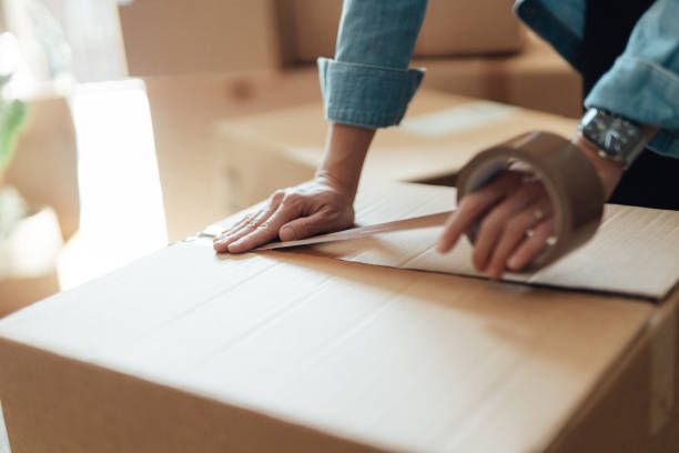 Female Hand Packing Cardboard Boxes — Lafayette, LA — Alex Louis Movers