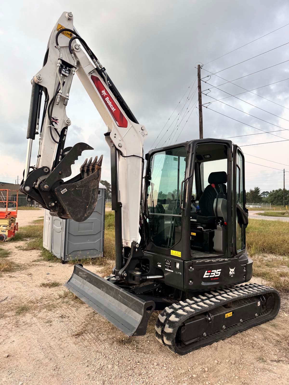 A small excavator is parked in a dirt field.