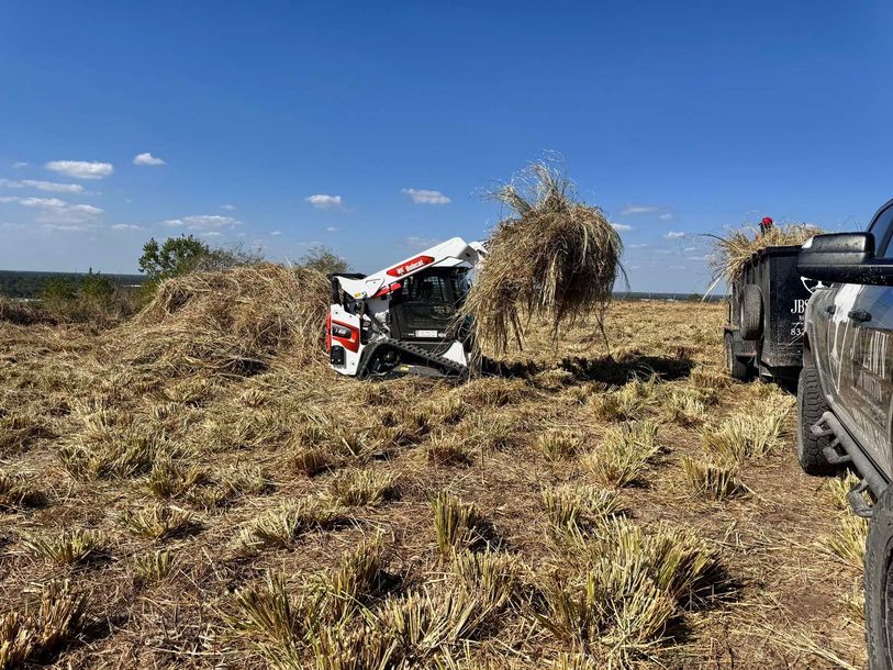 A car has crashed into a pile of hay in a field.