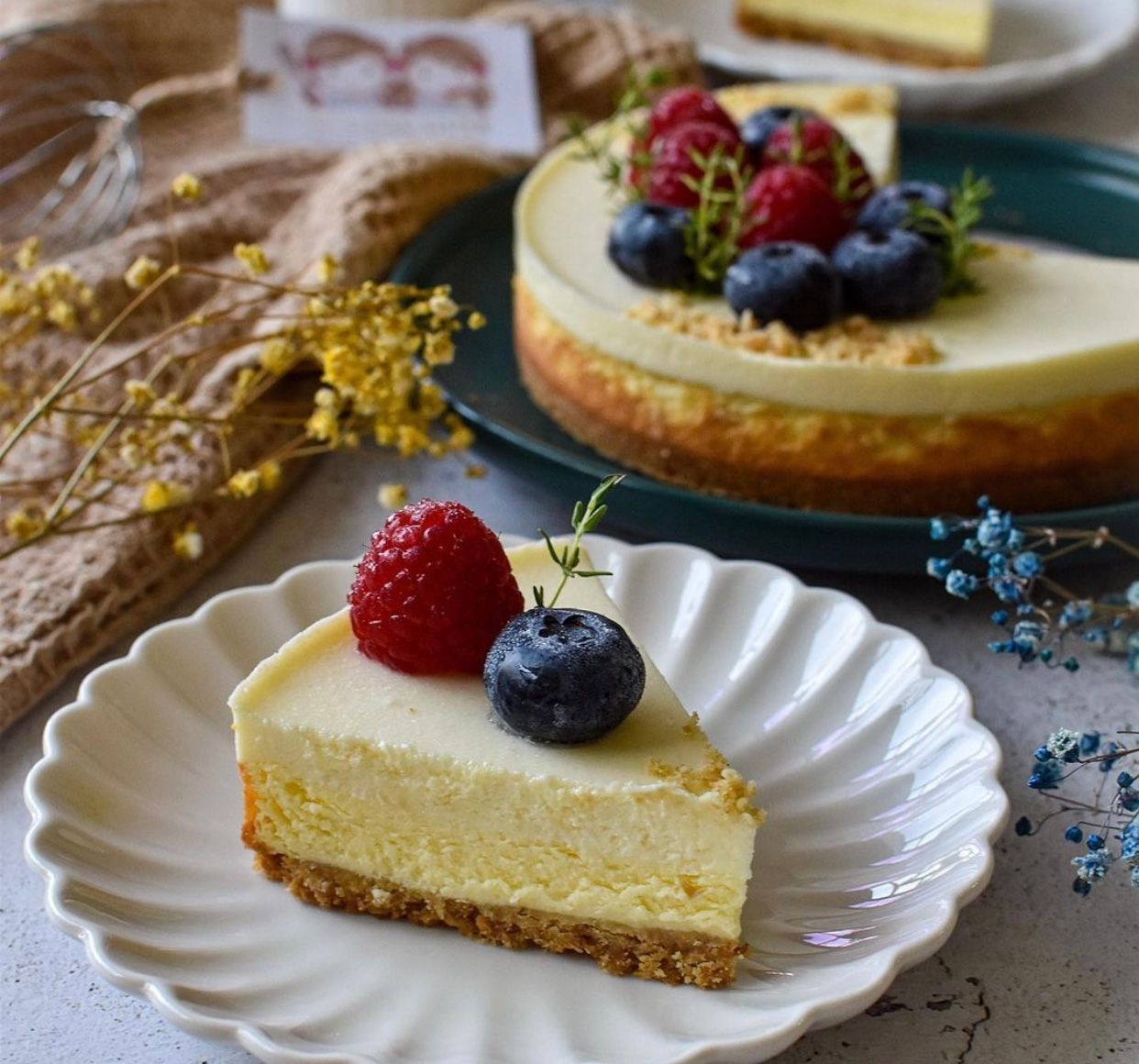 A slice of cheesecake with raspberries and blueberries on top