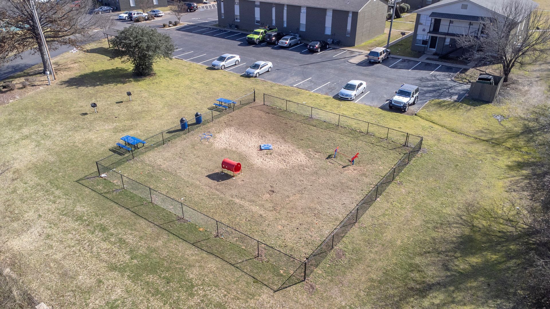 An aerial view of a dog park with a fence around it.