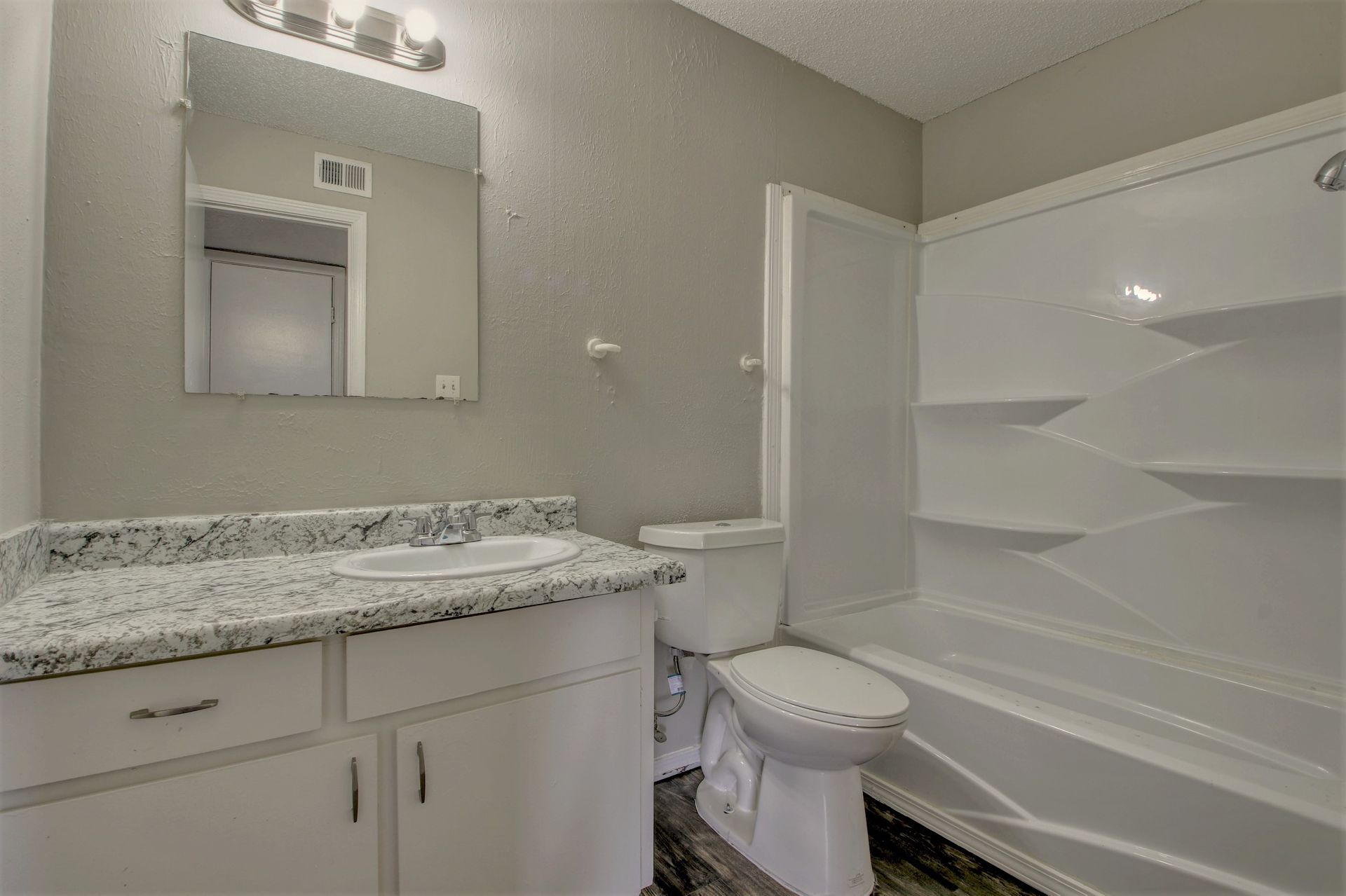 A bathroom with a toilet , sink , and bathtub.