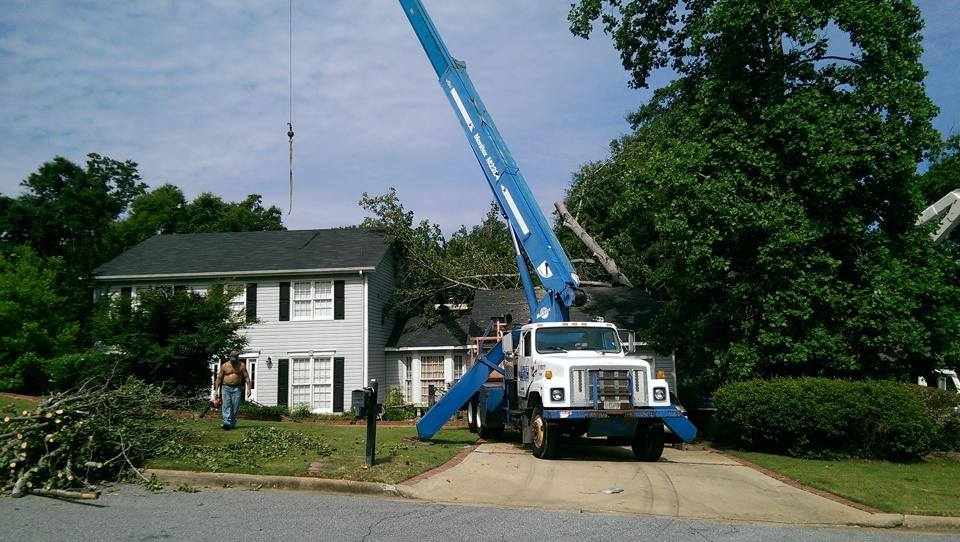 A blue and white truck is parked in front of a house.