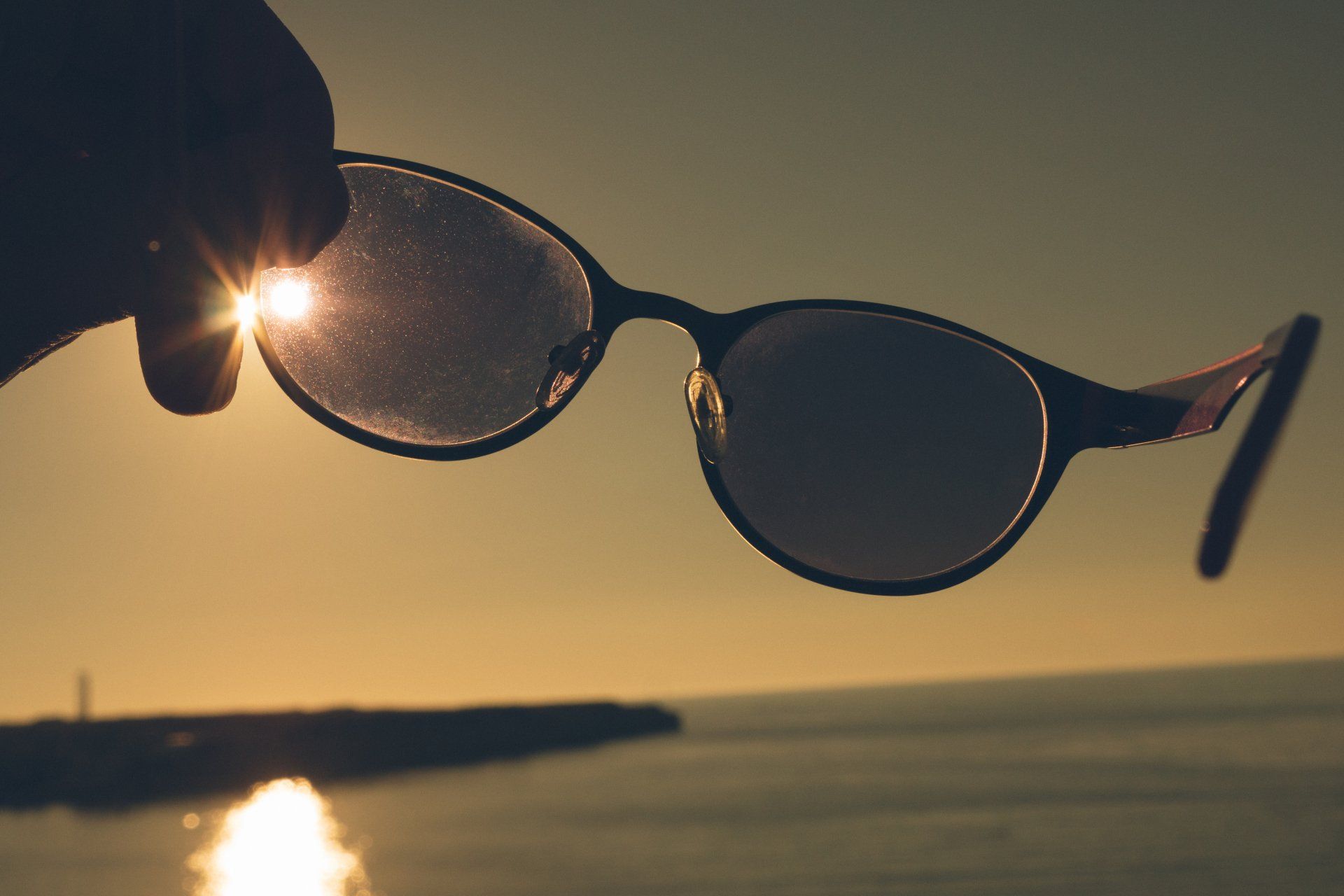 Somone holding up their glasses to the sunset