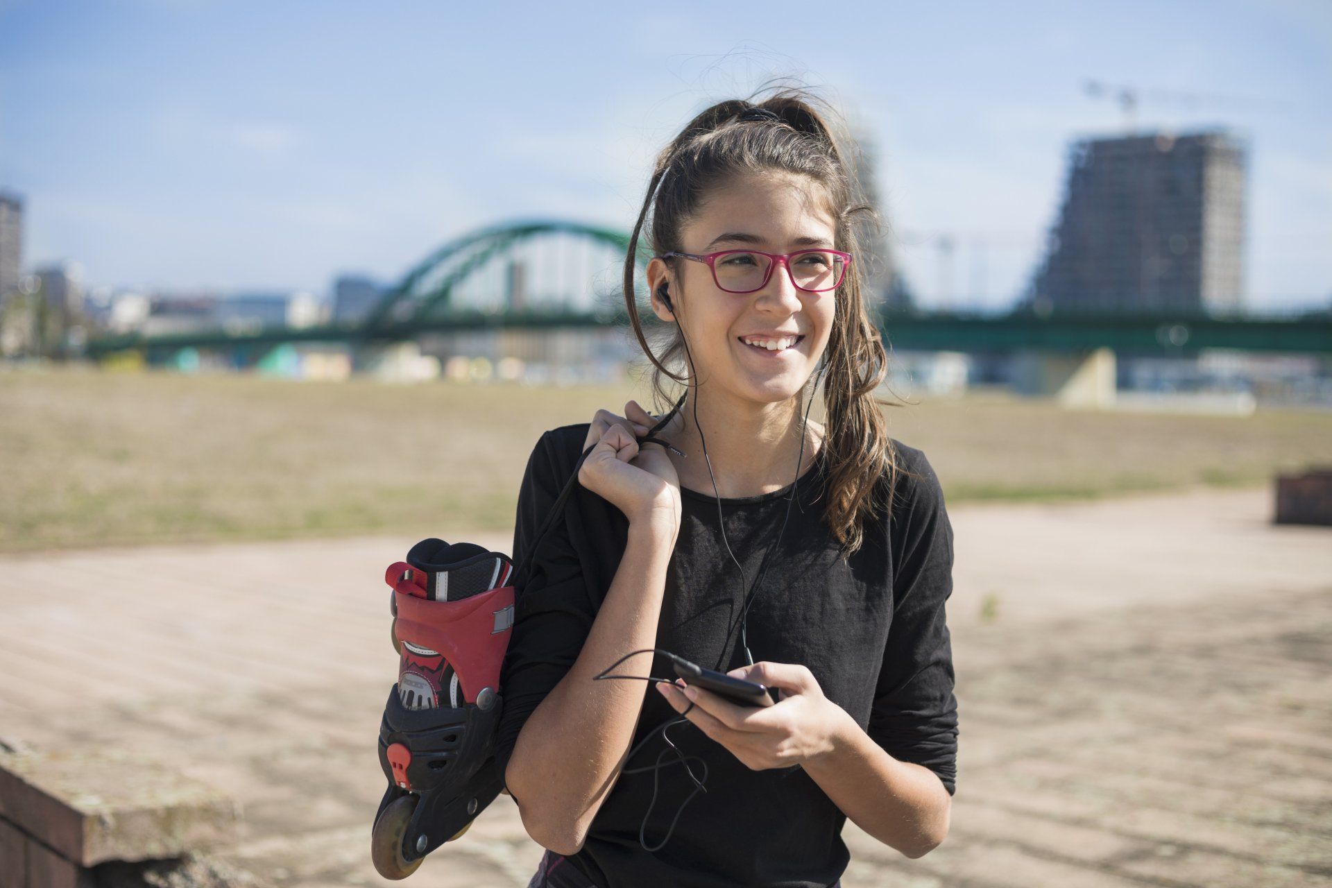 Girl wearing eyeglasses and carrying rollerblades