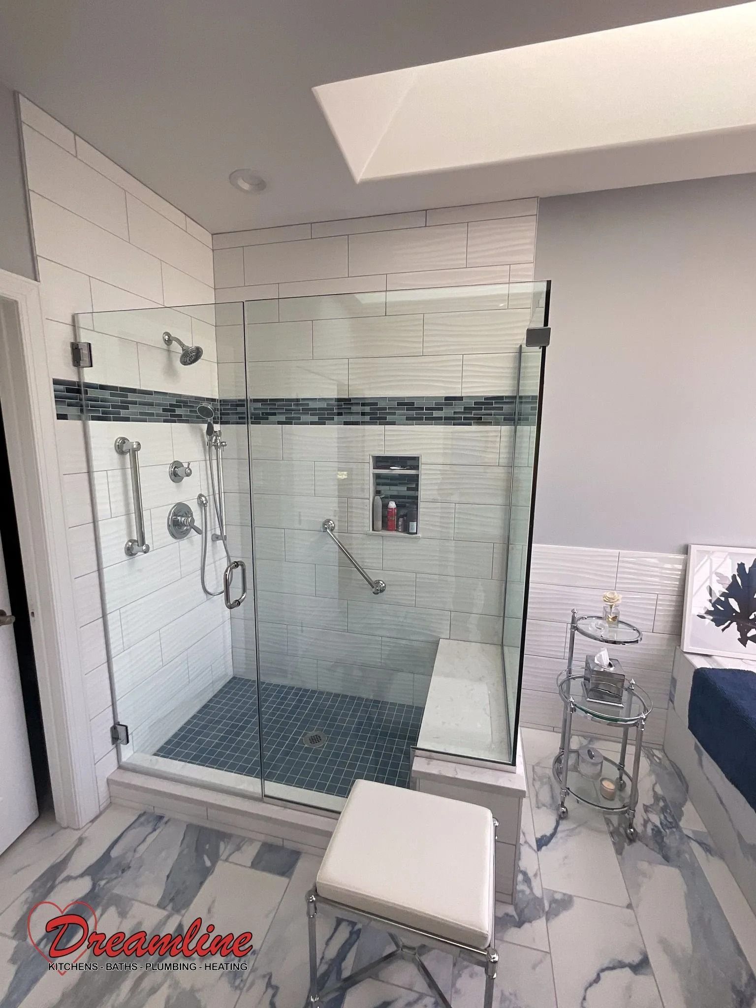 A bathroom with a walk in shower and a bench.
