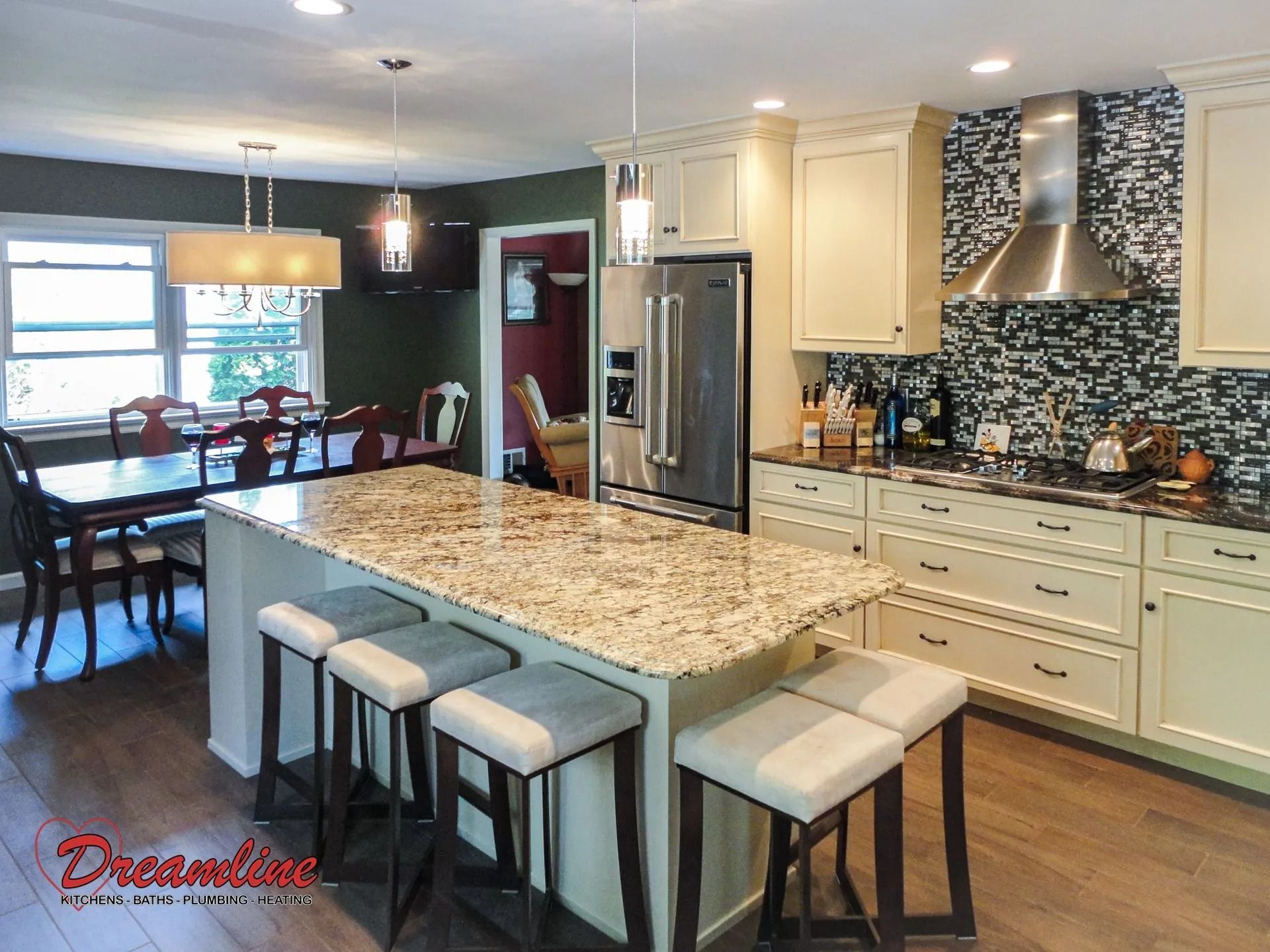 A kitchen with a large island in the middle and a dining room in the background.