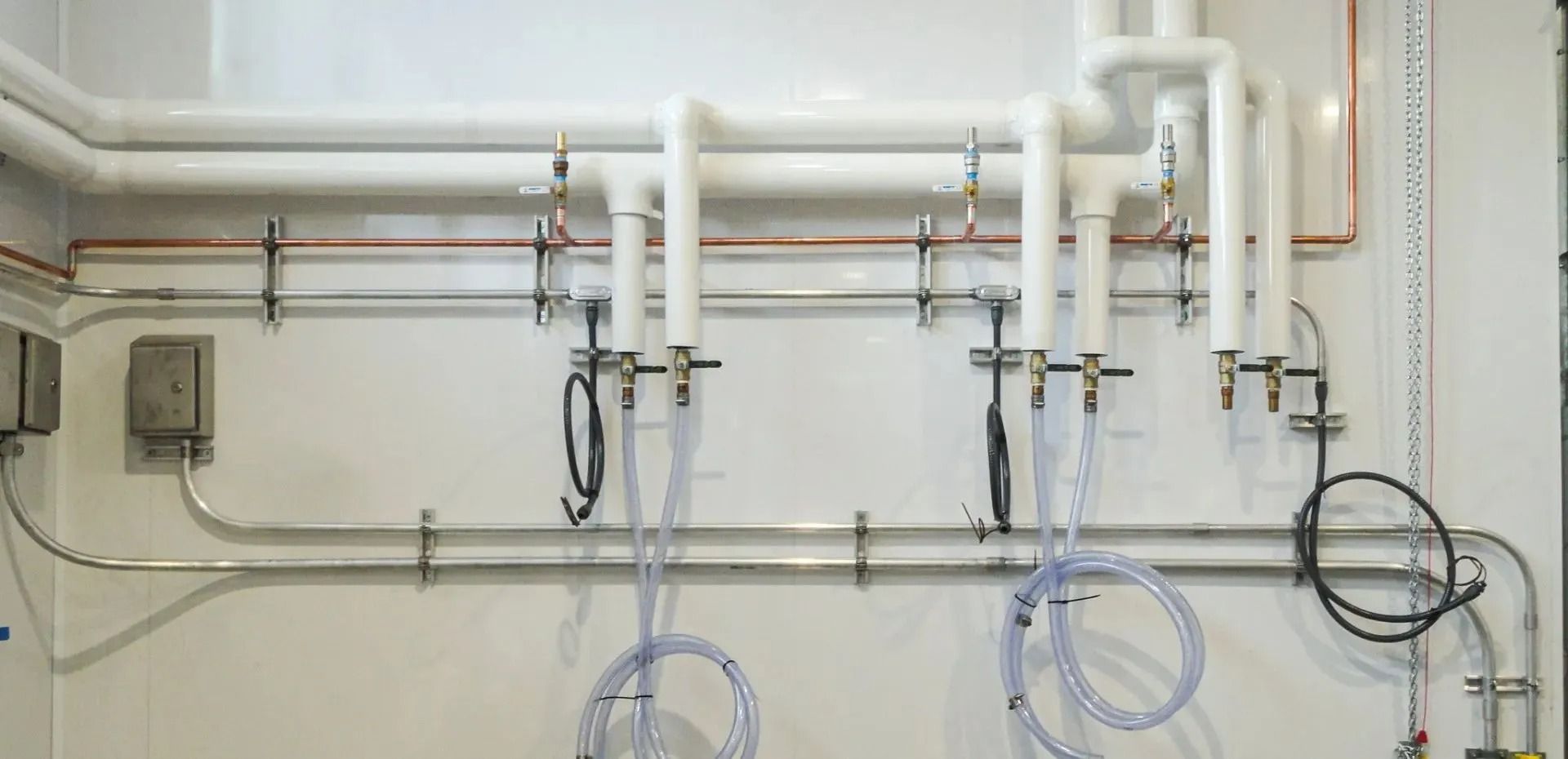 A room with a lot of pipes hanging on the wall.