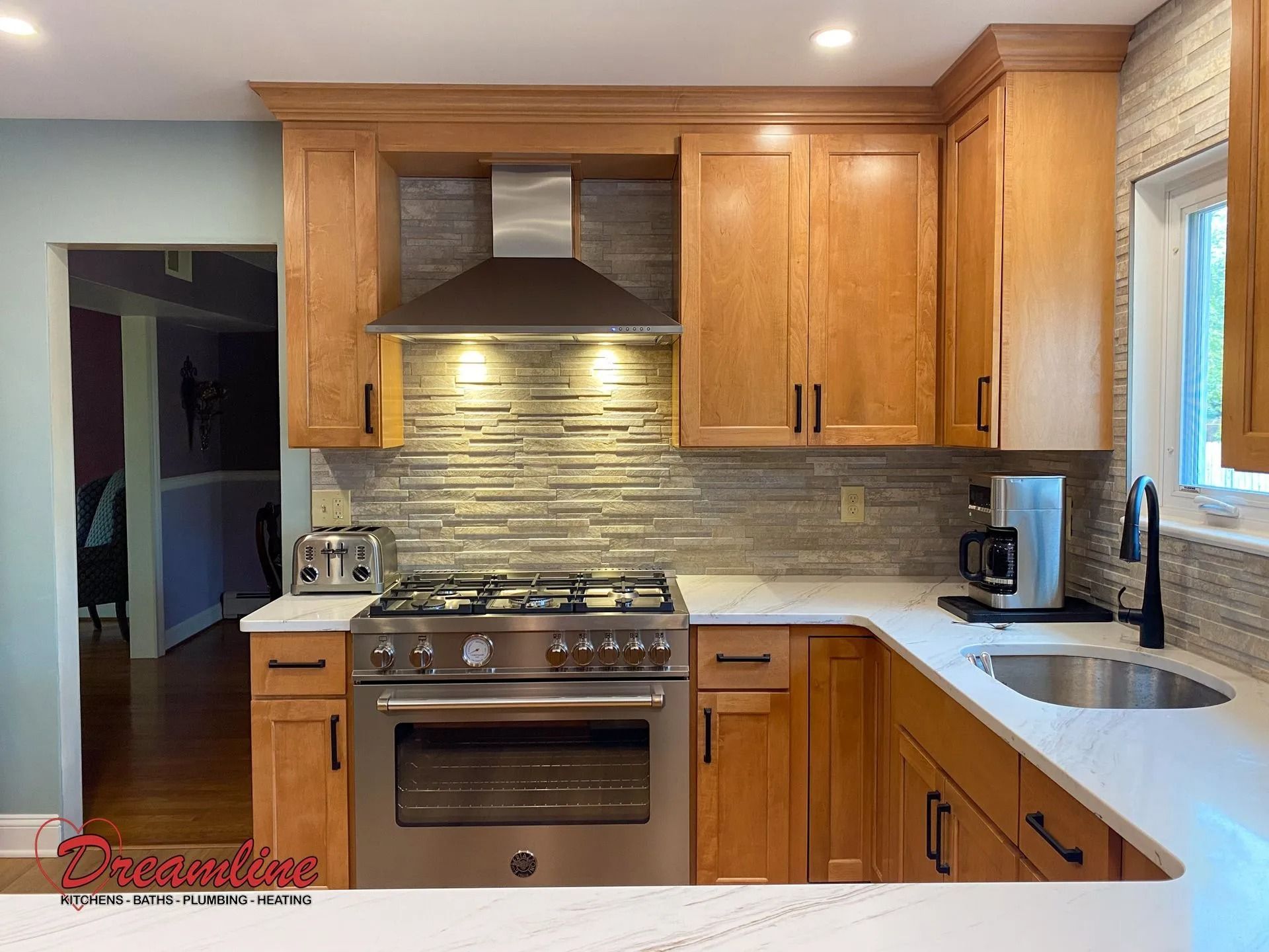 A kitchen with wooden cabinets , stainless steel appliances , a stove and a sink.