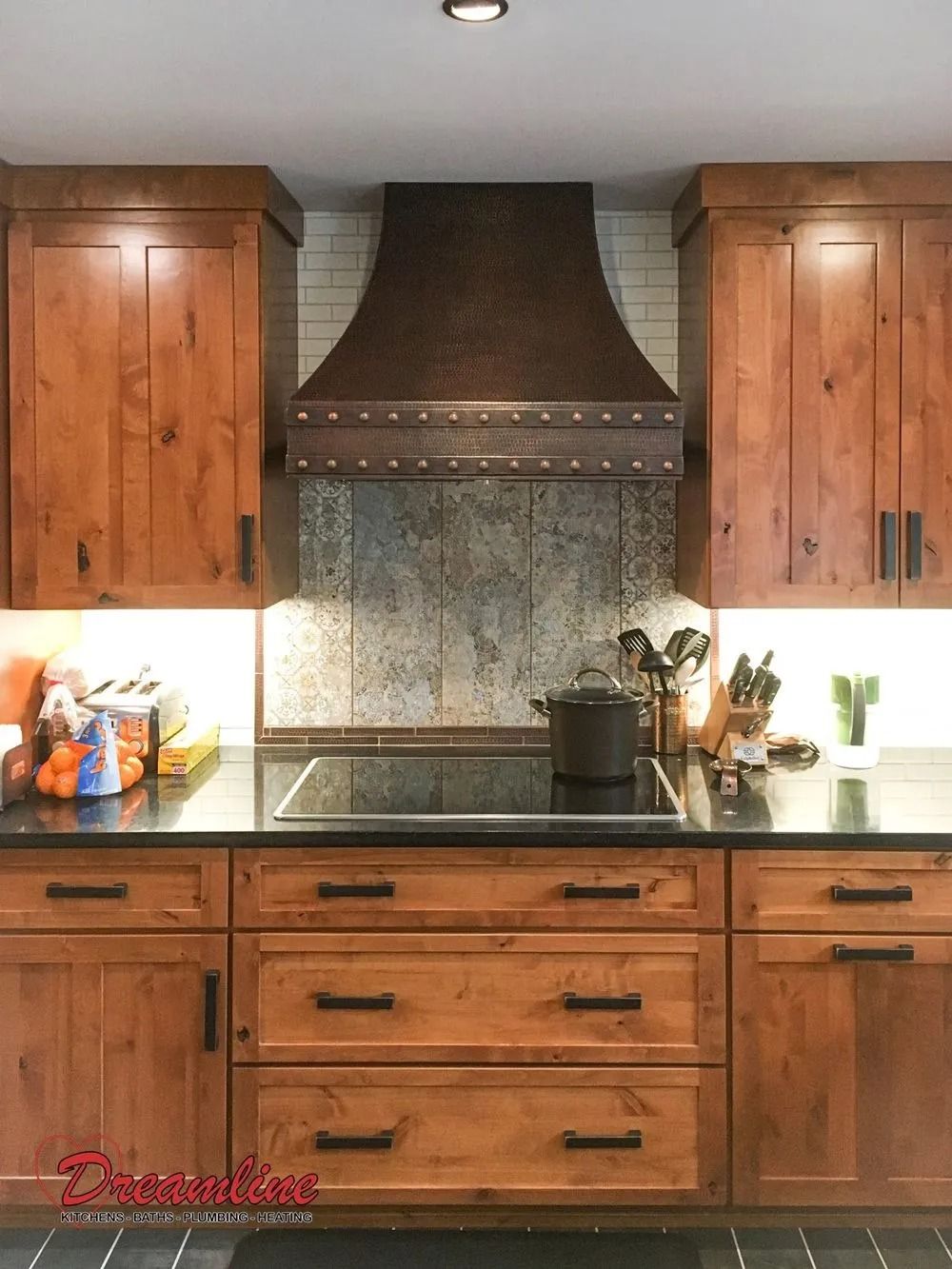 A kitchen with wooden cabinets and a stove top oven