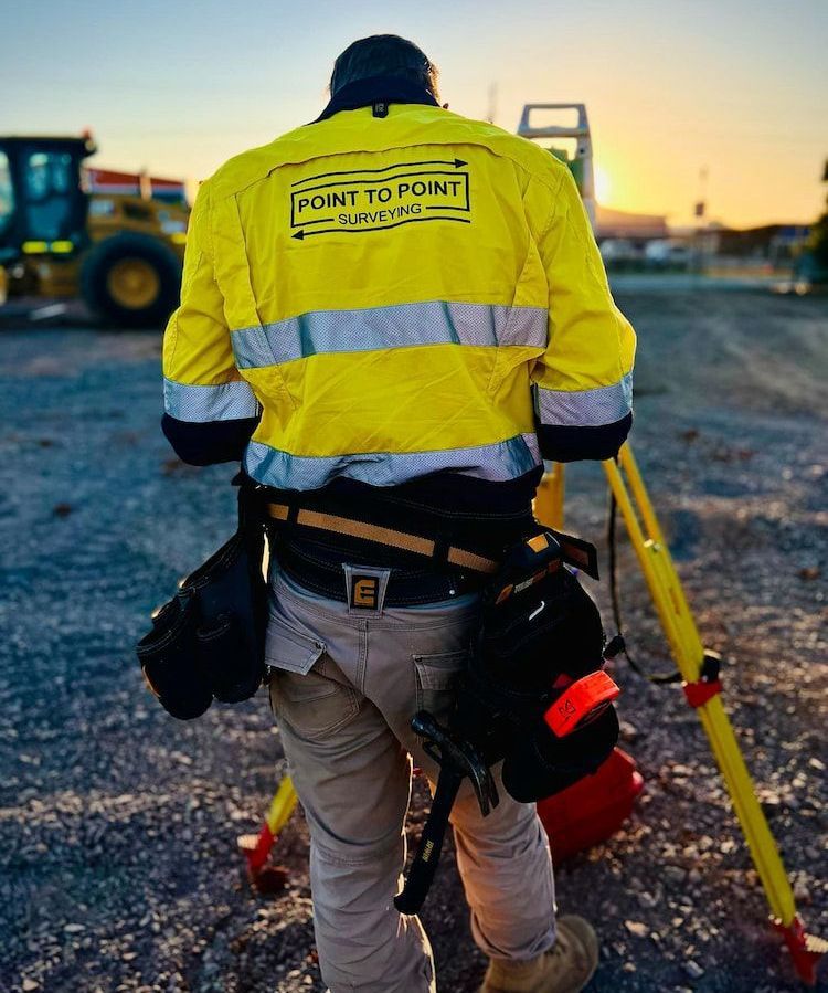 A Man Wearing a Yellow Jacket That Says Point to Point — Point to Point Surveying In Tatura, VIC